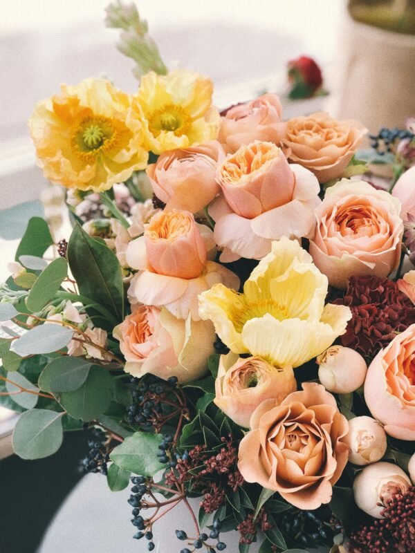 A beautiful floral bouquet featuring roses and poppies, perfect for weddings or celebrations.
